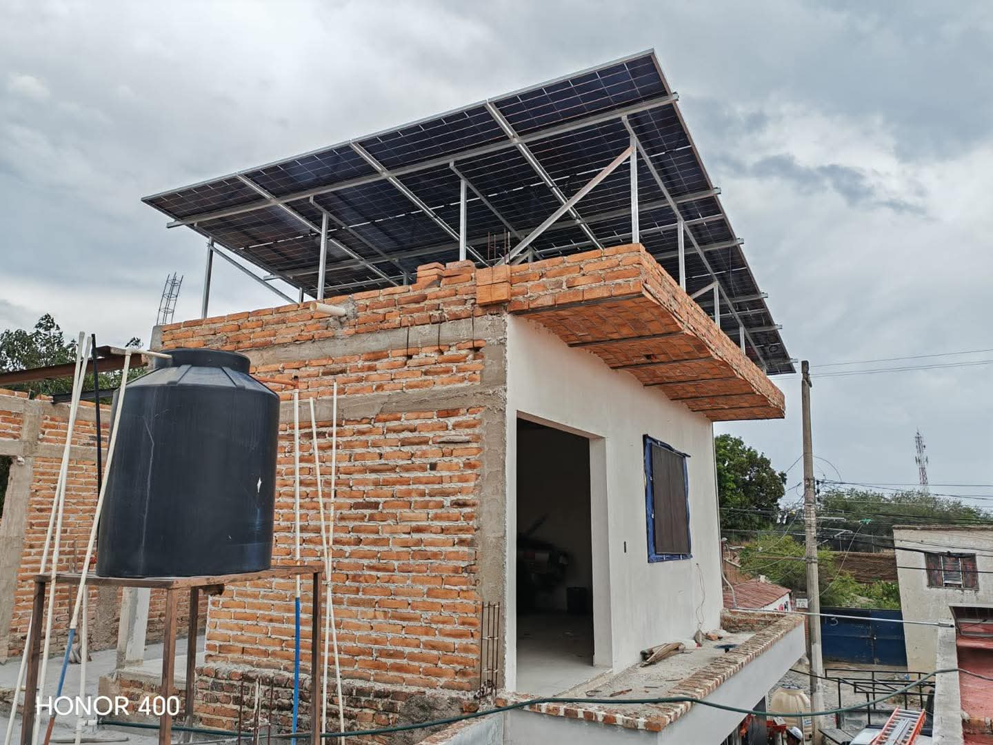 Paneles solares sobre estructura elevada en un edificio de ladrillo en El Refugio, Jalisco