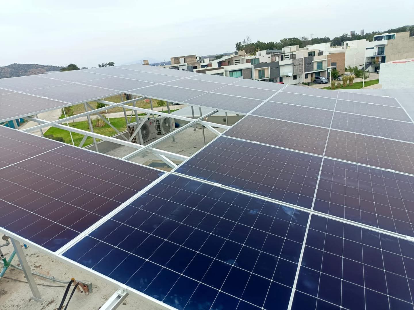 Paneles solares vistos desde arriba en Valle Imperial, con patio de pasto y minisplits